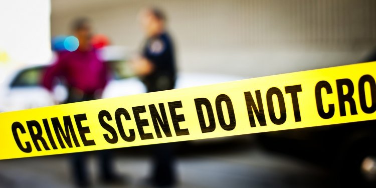 Closeup of crime scene tape with police officers and police car in background. Utahlypse 2011