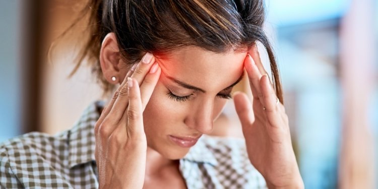 Shot of a uncomfortable looking woman holding her head in discomfort due to pain at home during the day